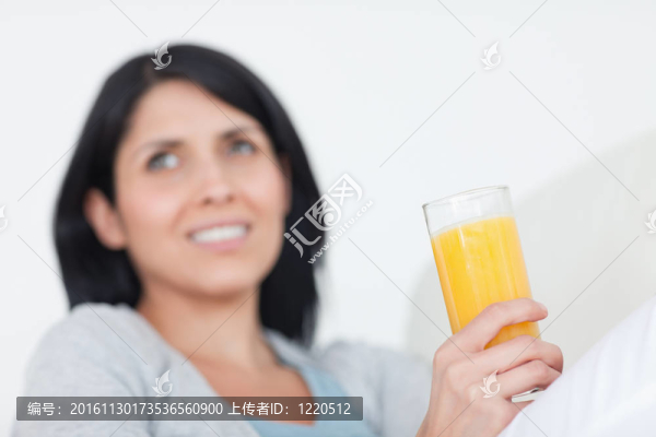 拿著一杯橙汁的女人