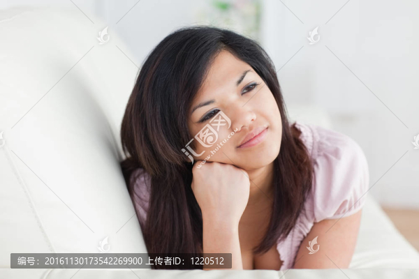 女人在沙發(fā)上休息，同時用手抱著頭