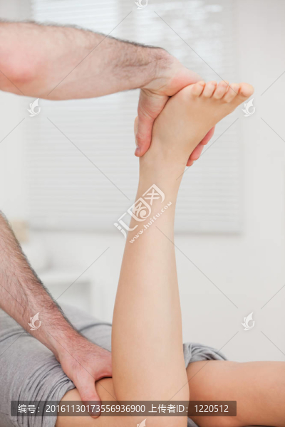 當(dāng)醫(yī)生在操縱她的腿時(shí)，女人躺著