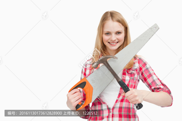 拿著一把錘子和一把鋸的女人