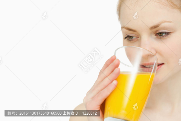 女人一邊看著一邊喝著橙汁