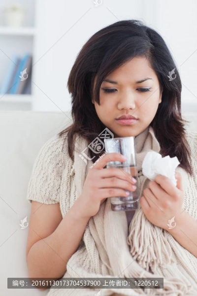 生病的女人拿著一杯水