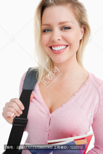 年輕女子一邊捧著筆記本一邊微笑