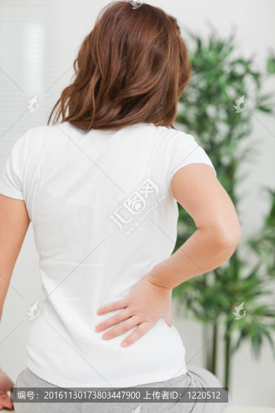 黑發(fā)女人坐在按摩她的背疼