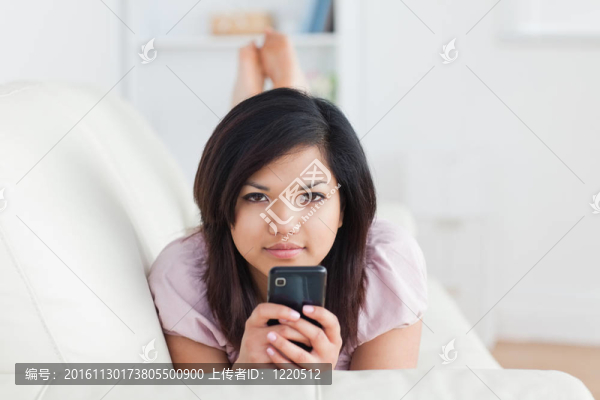 女人在沙發(fā)上休息，一邊拿著電話