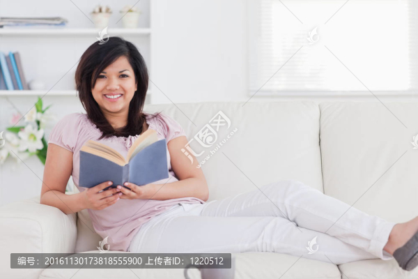 女人躺在沙發(fā)上拿著書(shū)