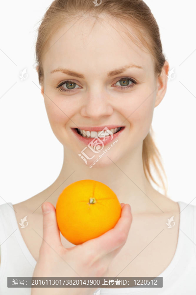 一個(gè)女人微笑著露出一個(gè)橙子