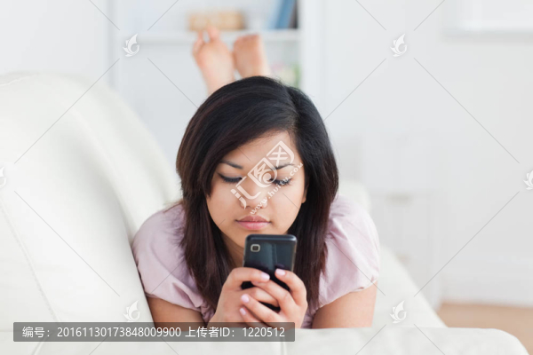 女人躺在沙發(fā)上拿著電話