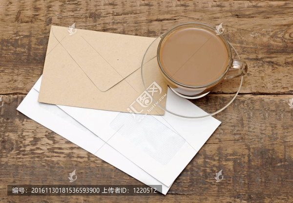木制桌子上的空白信封和玻璃咖啡杯