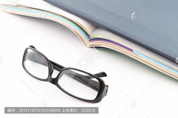 在打開的雜志前的眼鏡。