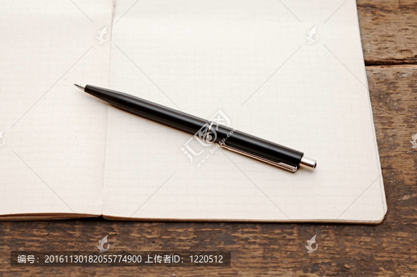 帶筆的舊筆記本在木頭桌上