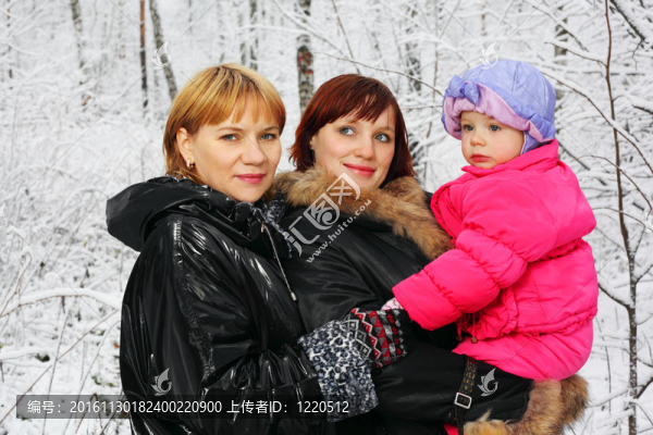冬天，媽媽和小女兒站在雪中的樹林里