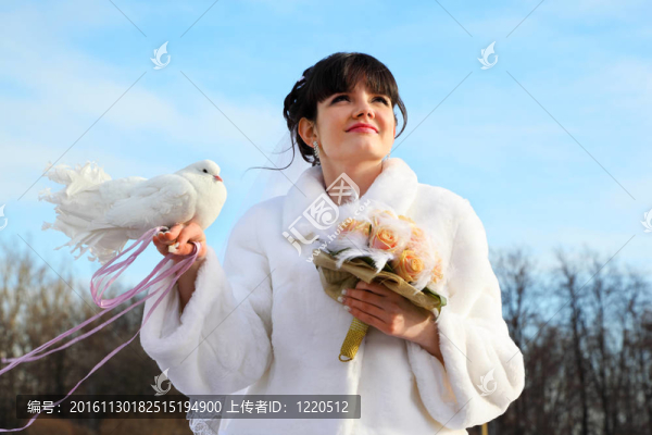 美麗的新娘帶著花束，白色的鴿子，在戶外看向遠(yuǎn)方