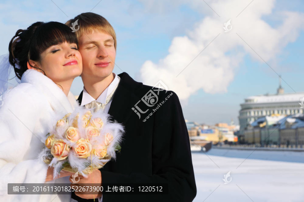 抱著微笑的新郎和新娘閉著眼睛，捧著一束玫瑰在戶外過冬；情侶站在橋上