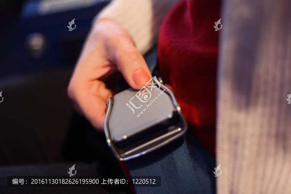 女的手帶著鎖的安全帶；專注于拇指；淺景深。