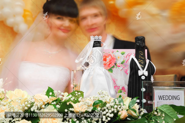 在婚禮桌上擺滿了盛裝盛裝的香檳酒；鮮花和新娘的模糊面孔
