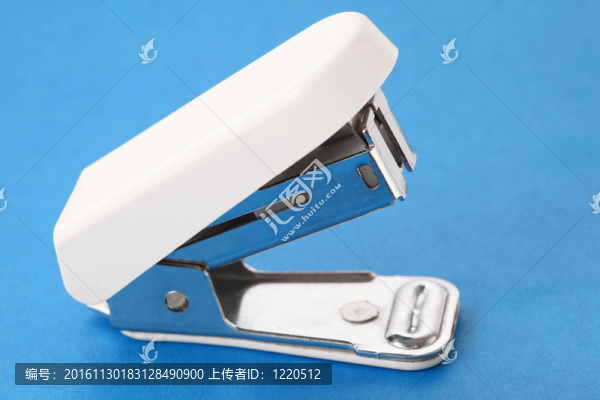 在藍色背景上的白色塑料訂書機的秘書工作