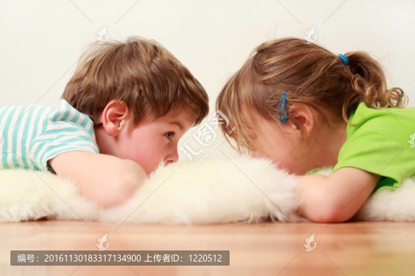 小弟弟和妹妹躺在地板上白皮膚，看著對(duì)方；專(zhuān)注于男孩