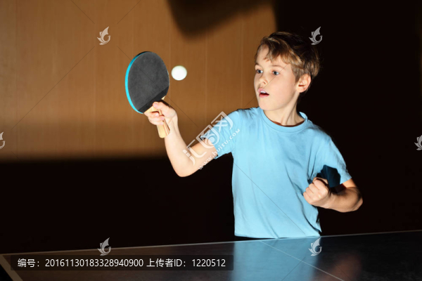 穿藍色襯衫打乒乓球的小男孩