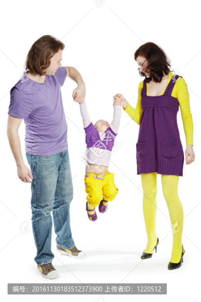 父親和母親手牽著他們的小女兒。