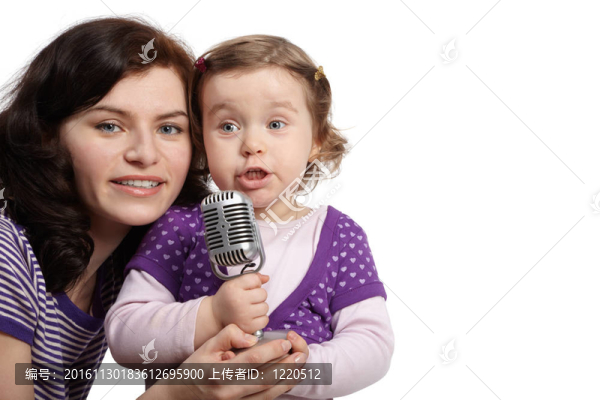 媽媽抱著她的小女兒，對著麥克風(fēng)唱歌。
