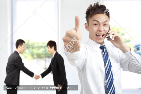 成功的商人在電話上豎起大拇指
