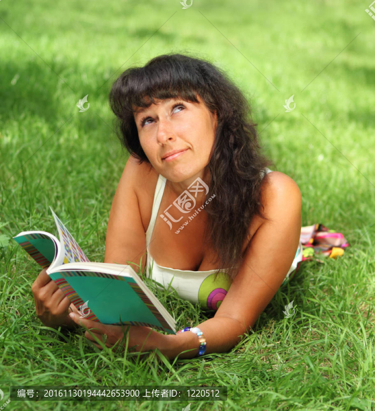 年輕女性閱讀在夏天公園的微笑的女