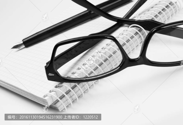 眼鏡和筆在記事本；