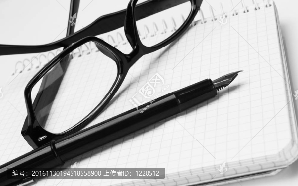 眼鏡和筆在記事本；