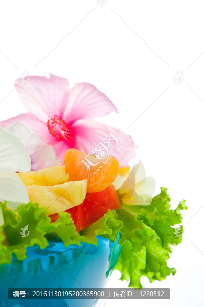 水果沙拉在藍色背景下的冰碗里有可食用的花