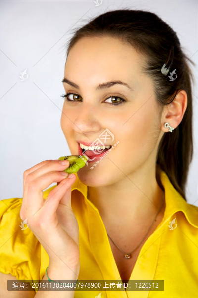 美麗的女孩吃新鮮獼猴桃微笑快樂