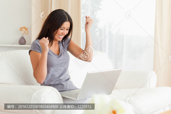 快樂女人坐在沙發(fā)上帶筆記本
