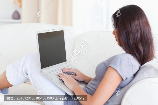 美女坐在沙發(fā)上帶筆記本