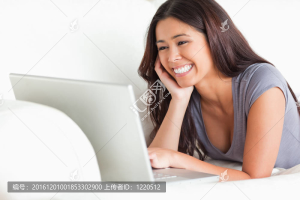 快樂的女人躺在沙發(fā)上用筆記