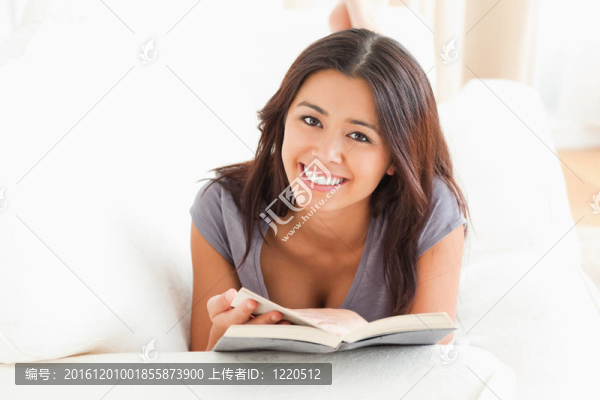 可愛的女人拿著一本書在她的哈