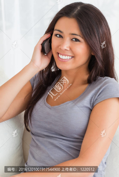 靠近一個(gè)打電話的女人坐在沙發(fā)上看著相機(jī)