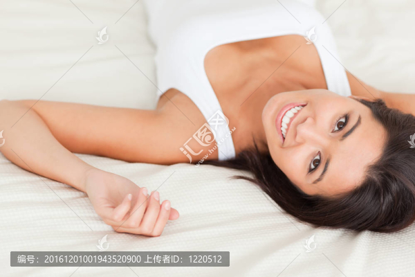 靠近一個黑發(fā)女人微笑著躺在床上