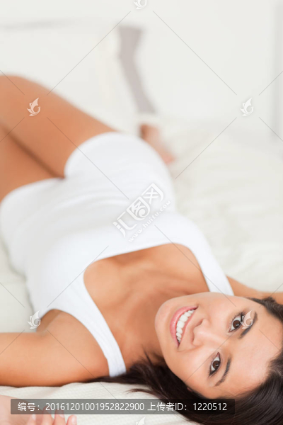 靠近一個黑色的迷人的女人躺在床上