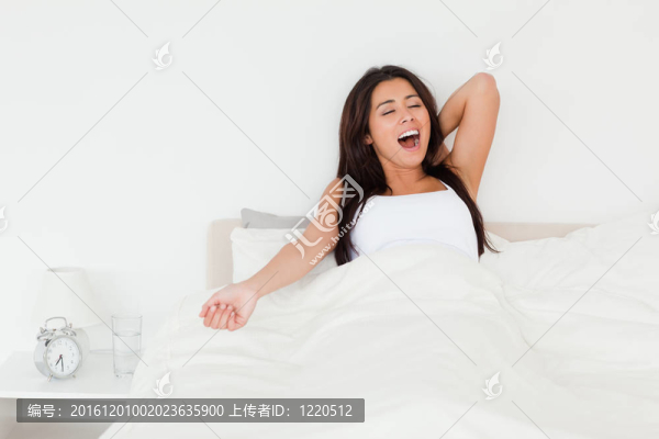 伸展的黑發(fā)女人在床上