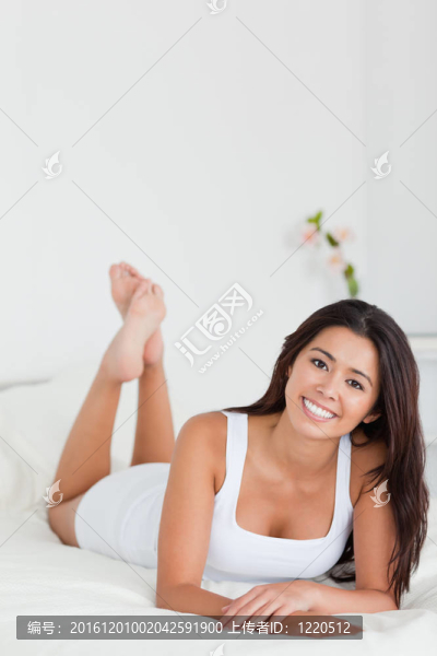 迷人的女人躺在床上交叉雙腿