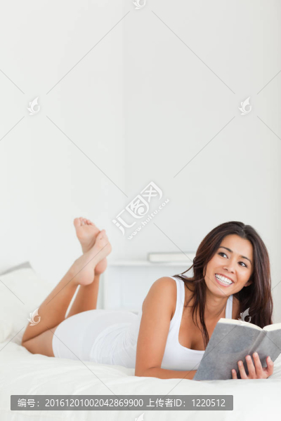 美麗的女人躺在床上的書