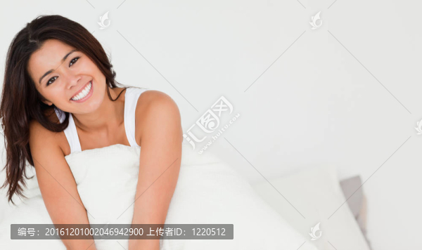 微笑的女人坐在床上