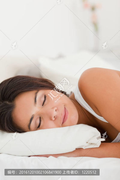 一個(gè)熟睡的美女躺在床單下面