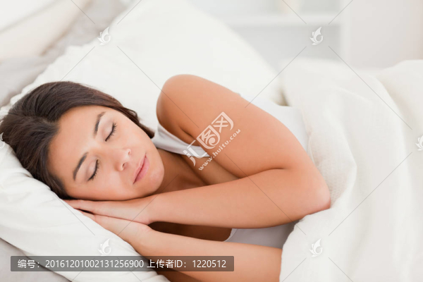 熟睡的黑發(fā)女子躺在床單下