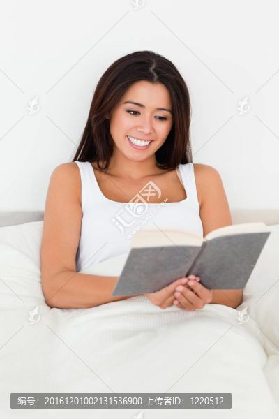 黑發(fā)女人躺在床上看書