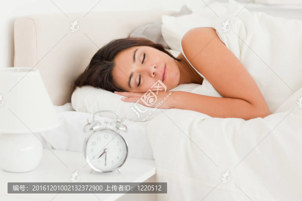 一個可愛的女人睡在床單下