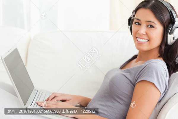 關(guān)閉耳機(jī)和筆記本坐在沙發(fā)上的女人