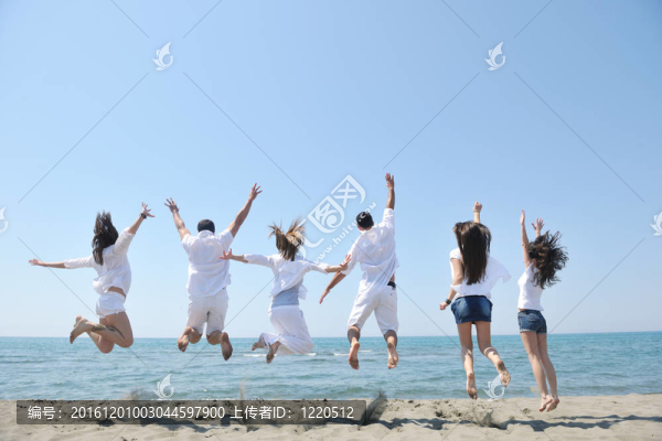 快樂人團體在海灘上玩樂和跑步