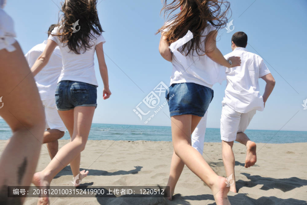 快樂人團體在海灘上玩樂和跑步