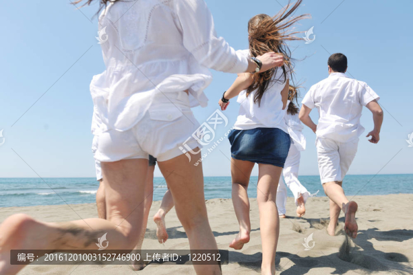 快樂(lè)人團(tuán)體在海灘上玩樂(lè)和跑步